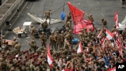 Anti-government protesters scuffle with Lebanese army soldiers during a protest in the town of Jal el-Dib north of Beirut, Lebanon, Oct. 23, 2019. 