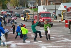 Children scramble for candy during a homecoming parade, Oct. 16, 2020, in Wessington Springs, S.D. The parade had to be postponed because of a coronavirus outbreak that killed five residents of the local nursing home.