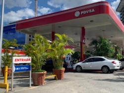 En la entrada de una gasolinera en Caracas se ve el anuncio de que aceptan divisas y petros, token creado por el gobierno venezolano respaldado por recursos naturales. Agosto 2021. Foto: VOA.