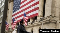 Un peatón con mascarilla pasa delante de la Bolsa de Valores Nueva York, cuando los mercados siguen reaccionando a la crisis económica generada por la pandemia de COVID-19.