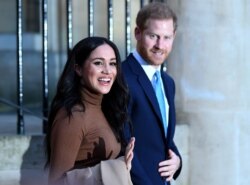 FILE - Britain's Prince Harry, Duke of Sussex and Meghan, Duchess of Sussex react as they leave after her visit to Canada House in London, Jan. 7, 2020.