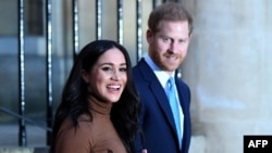 FILE - Britain's Prince Harry, Duke of Sussex and Meghan, Duchess of Sussex react as they leave after her visit to Canada House in London, Jan. 7, 2020. 