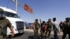 Agentes de la policía sacan a mujer mientras inmigrantes indocumentados bloquean una carretera en la frontera chilena y peruana mientras permanecen atrapados en Chile, luego de que Perú se negara a abrir sus fronteras el 23 de abril de 2023.