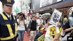 Police herd marchers along the curb as the streets are
not blocked off for the demonstration in Tokyo, Japan, April 16, 2011