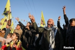 Syrian Kurds make the peace sign as they gather after Turkey's jailed militant leader Abdullah Ocalan called on his Kurdistan Workers' Party to lay down its arms, a move that could have far-reaching consequences for the region, in Hasakah, Syria, on Feb. 27, 2025.