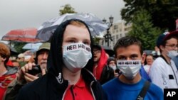 People gather to collect signatures to cancel the results of voting on amendments to the Constitution in Moscow, Russia, July 15, 2020. Writing on the face masks reads "no." 