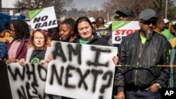 FILE - Women protest after more than 80 men suspected of the gang rapes of eight women appeared in court, outside the Krugersdorp Magistrate Court in South Africa, Aug. 1, 2022.