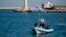 FILE - Italian police patrol a port in southern Italy, April 20, 2018. 
