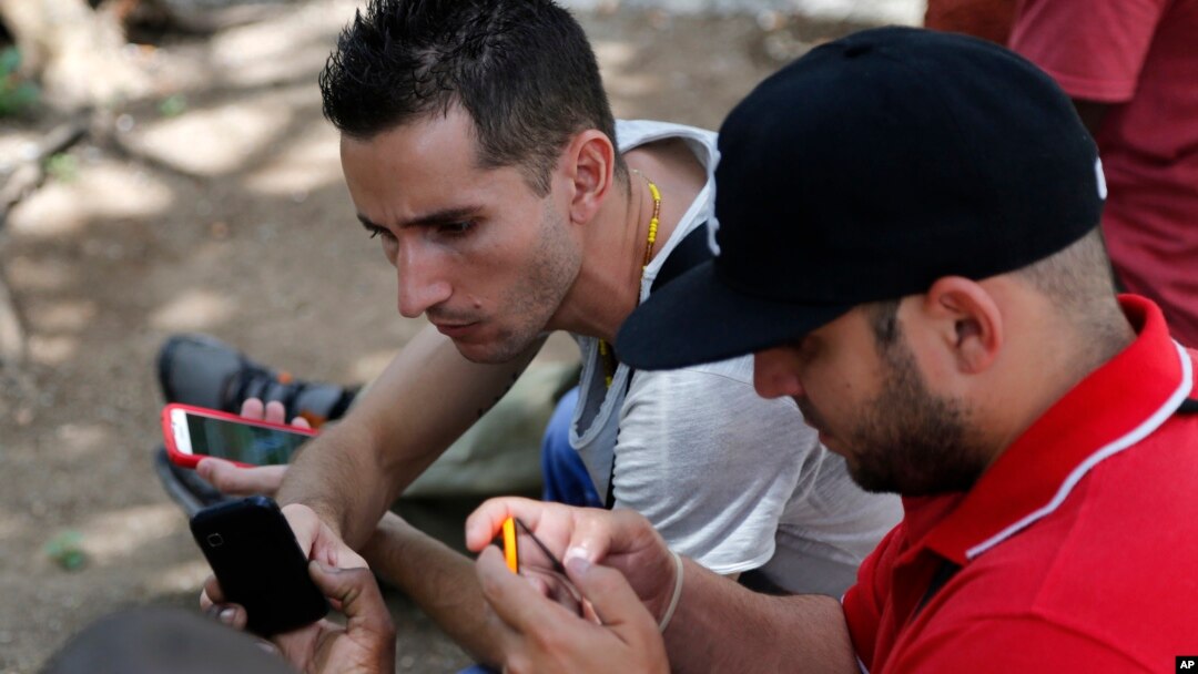 Internet users go online with their smartphones using the first public Wi-Fi hotspot in Havana, Cuba, July 2, 2015.