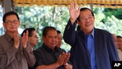 Cambodia's Prime Minister Hun Sen waves on his arrival for a groundbreaking ceremony for a bridge over the Tonle Sap river, at Russey Keo village near Phnom Penh, Cambodia, Monday, Oct. 23, 2017. (AP Photo/Heng Sinith)