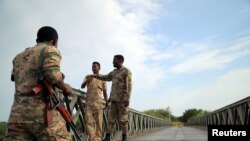 Members of Amhara special forces stand guard on the Tekeze river bridge near Ethiopia-Eritrean border near the town of Humera, Ethiopia, July 1, 2021. 