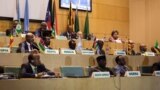 FILE - African Union Chairman Moussa Faki, second left at top, sits with members of the Intergovernmental Authority for Development as they attend a signing ceremony for a cease-fire agreement among South Sudanese parties to end the four-year war in the country, at the headquarters of African Union in the Ethiopian capital, Addis Ababa, Dec. 21, 2017. South Sudan peace talks were adjourned for several weeks on Feb. 16, 2018.