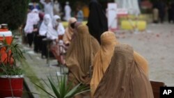 Women wait to receive cash under the governmental emergency cash program for families in need during a government-imposed nationwide lockdown to help contain the spread of the coronavirus in Peshawar, Pakistan, April 9, 2020.