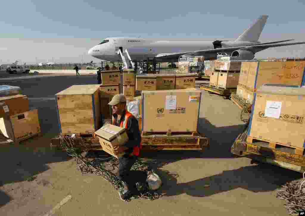 A Syrian airport worker carries a box with equipment for the U.N. observers at the Damascus airport.