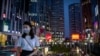 People wearing face masks to protect against the coronavirus ride an escalator at a shopping and office complex in Beijing, Thursday, July 16, 2020. China's economy has rebounded from a painful contraction to grow by 3.2% in the latest quarter…