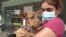 People passing by can hold, pet as well as play with the dogs to see if they feel a connection and consider adopting one. (Dave Grunebaum/VOA)
