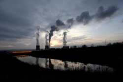 FILE - Smoke rises from chimneys of the Turow power plant located by the Turow lignite coal mine near Bogatynia, Poland, Nov. 19, 2019.