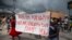 FILE - People carry a banner with a message that reads in Creole: 'No to kidnappings, no to violence against women ! Long live Christian Aid Ministries,' in Titanyen, north of Port-au-Prince, Haiti, Oct. 19, 2021.