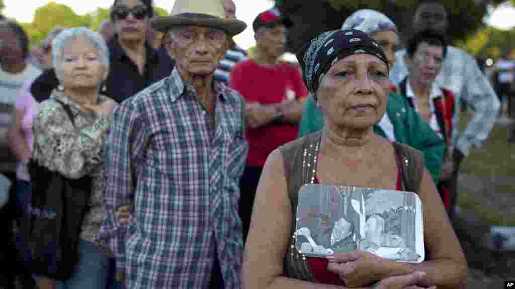 Une femme tenant en main une photo du défunt Fidel Castro et du défunt président vénézuélien Hugo Chavez, &nbsp;dans la Place de la Révolution pour rendre hommage à Fidel Castro, à La Havane, Cuba, le 28 novembre 2016.