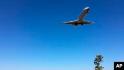 ARCHIVO - En esta fotografía del 26 de enero de 2018, la gente observa un avión de pasajeros volar sobre Gravelly Point Park cuando aterriza en el Aeropuerto Ronald Reagan National de Washington.