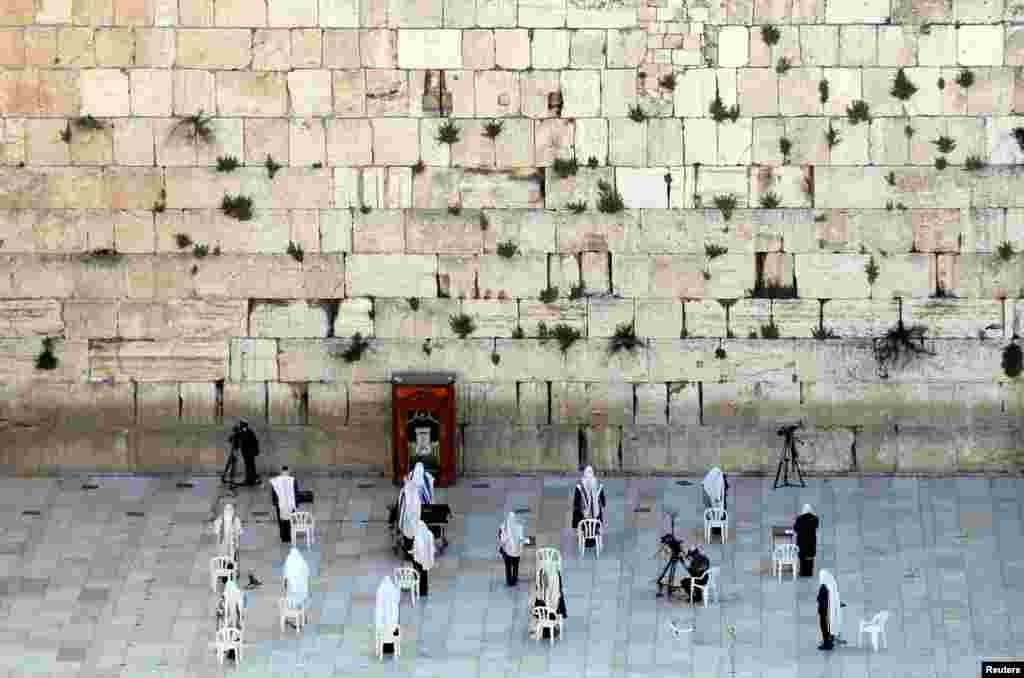 A small number of Jewish worshipers pray during the priestly blessing, a traditional prayer which usually attracts thousands of worshipers at the Western Wall on the holiday of Passover, amid the coronavirus outbreak, in Jerusalem&#39;s Old City.