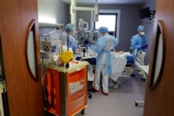 FILE - Medical staff work in the intensive care unit where COVID-19 patients are treated at Cambrai hospital, France, March 25, 2021.