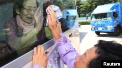 A North Korean woman bids farewell to her South Korean family members as they leave after a reunion at Mount Kumgang resort, North Korea, Aug. 22, 2018. 