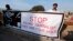 FILE - Journalists hold a banner while taking part in a demonstration in front of the Parliament building in Islamabad on January 28, 2013. 