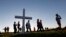 Attendees pass a wooden cross as they arrive at a candlelight vigil for the victims of the shooting at Marjory Stoneman Douglas High School in Parkland, Florida, Feb. 15, 2018. 