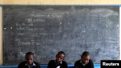 Wanafunzi wakitumia meza ya mwalimu darasani kujisomea wakati wa mgomo wa walimu wa nchi nzima wakidai nyongeza ya mshahara na hivyo kusimamisha masomo mjini Nairobi June 25, 2013. REUTERS/Noor Khamis