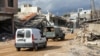 Lebanese soldiers gesture as they drive through a damaged site at the village of Khiam, Lebanon, near the border with Israel, on Jan. 23, 2025.