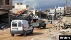 Lebanese soldiers gesture as they drive through a damaged site at the village of Khiam, Lebanon, near the border with Israel, on Jan. 23, 2025.