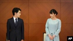 La exprincesa Mako de Japón, a la derecha, la hija mayor del príncipe heredero Akishino y la princesa Kiko, y su esposo Kei Komuro, se miran durante una conferencia de prensa para anunciar su matrimonio en un hotel en Tokio, Japón, el martes 26 de octubre. 2021.