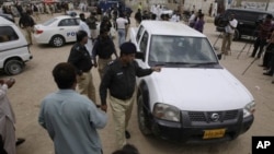 Pakistani police officers inspect U.N. vehicle attacked by gunmen inKarachi, Pakistan, July 17, 2012.