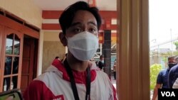 Putra Presiden Jokowi, Gibran Rakabuming Raka ( jaket merah putih - bermasker) saat blusukan sejumlah wilayah di Solo, Senin (21/12). (Foto : VOA/ Yudha Satriawan)