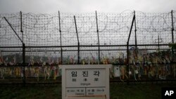 A directional sign showing the distance to N. Korea's Kaesong city and S. Korea's capital Seoul is seen near the wire fences decorated with ribbons written with reunification wishing at the Imjingak Pavilion in Paju, S. Korea, May 26, 2020.