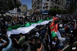 FILE - Palestinians march in a rally marking the 75th anniversary of what they call the "Nakba," or "catastrophe," in the West Bank city of Ramallah, Monday, May 15, 2023. The march marked the anniversary of their mass displacement during the 1948 war around Israel's creation.