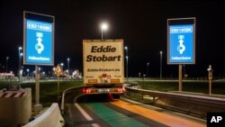 FILE - A truck from Britain drives through a customs area to enter France at the Eurotunnel terminal, in Coquelles, northern France, Jan. 1, 2021.