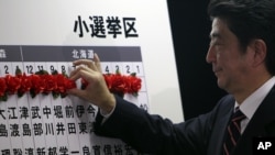 Ông Shinzo Abe, nhà lãnh đạo đảng Dân chủ Tự do, đang đối lập chính của Nhật Bản, đánh dấu tên của người đắc cử trong cuộc bầu cử quốc hội 16/12/12