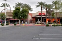 An empty parking lot leading to a closed AMC movie theatre and restaurants sits idly, March 18, 2020, in Phoenix. The city of Phoenix issued a state of emergency on Tuesday ordering all bars, gyms and other indoor facilities to close.
