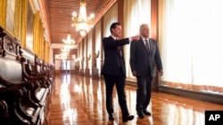 In this photo released by Mexico's presidential press office, Mexico's President-elect Andres Manuel Lopez Obrador, right, is escorted by Mexico's current President Enrique Pena Nieto through the National Palace in Mexico City, July 3, 2018. 