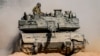 Israeli soldiers drive a tank at a staging ground near the border with the Gaza Strip, in southern Israel, May 5, 2024.