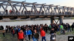 People and relatives of victims waiting on the bank of the Tigris river where the ferry sank in Mosul, Iraq, Thursday, March 21, 2019.