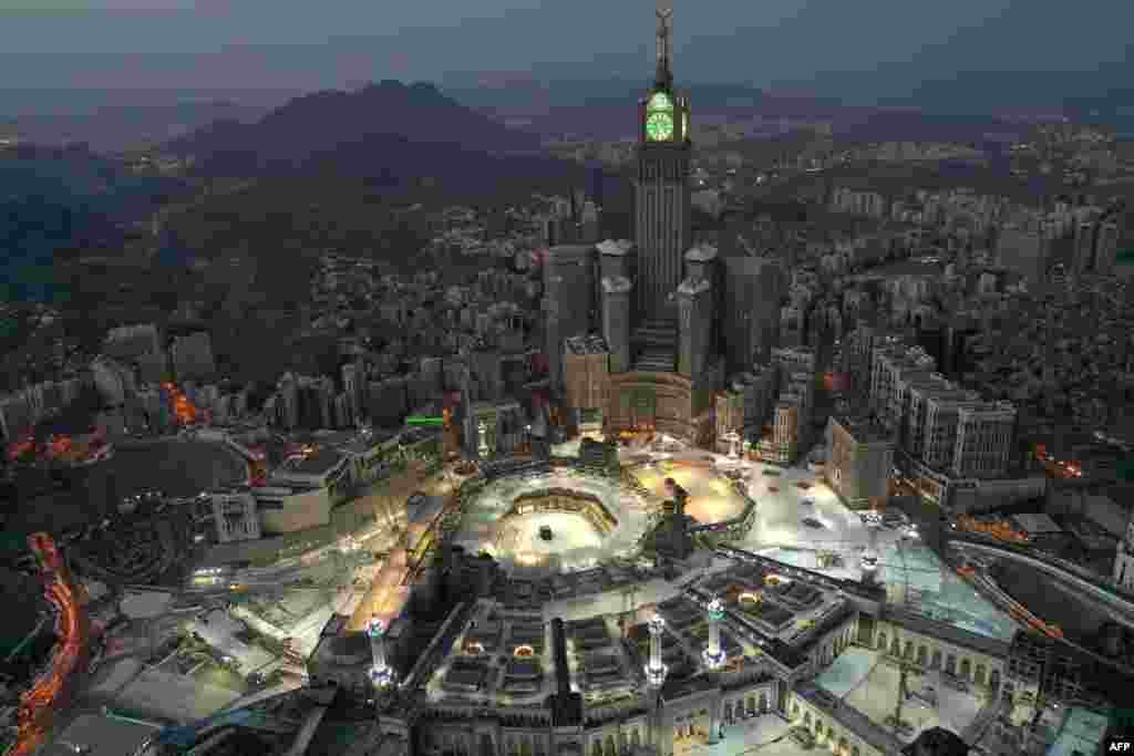 An aerial view of Saudi Arabia's holy city of Mecca, with the Abraj al-Bait Mecca Royal Clock Tower overlooking the Grand Mosque and Kaaba in the center, is seen during the early hours of Eid al-Fitr.