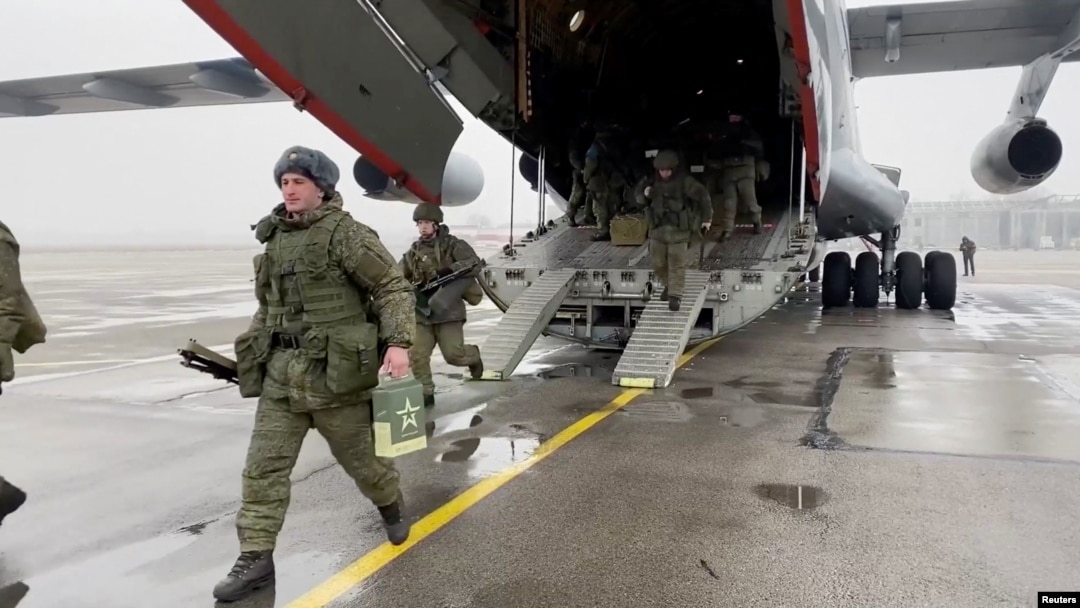 A still image from video released by Russia's Defence Ministry shows Russian service members disembarking from a military aircraft, at an airfield in Kazakhstan, Jan. 7, 2022. 