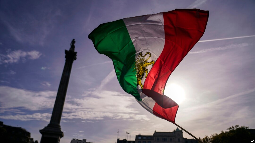 Masyarakat mengibarkan bendera Iran pra-revolusi Islam saat protes terhadap otoritas Iran, di London, Sabtu, 29 Oktober 2022, sebagai ilustrasi. Iran pada Minggu (4/12) mengeksekusi empat pria yang dituduh telah bekerja sama dengan agen intelijen Israel Mossad. (Foto: AP)