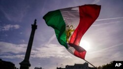 Masyarakat mengibarkan bendera Iran pra-revolusi Islam saat protes terhadap otoritas Iran, di London, Sabtu, 29 Oktober 2022, sebagai ilustrasi. Iran pada Minggu (4/12) mengeksekusi empat pria yang dituduh telah bekerja sama dengan agen intelijen Israel Mossad. (Foto: AP)