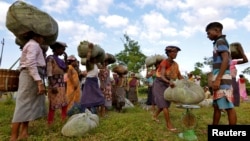 FILE - Tea garden workers gather to weigh tea leaves after plucking them at a tea estate in Nagaon district, in the northeastern state of Assam, India, Nov. 2, 2016. 