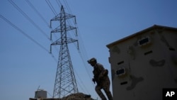 FILE - Members of the Iraqi army secure main power lines between regional towers in Baghdad, Iraq, Aug. 8, 2023.