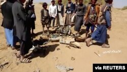 People inspect purported plane crash site in, said to be, Al-Jawf, Yemen on, said to be, February 15, 2020 in this still image taken from a video. (Houthi Media Centre/via Reuters) 